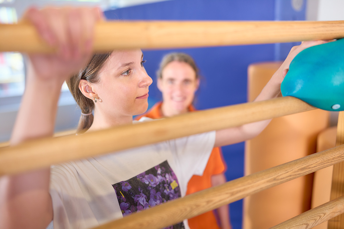 Zwei Frauen auf einem Klettergerüst, führen eine Übung aus.