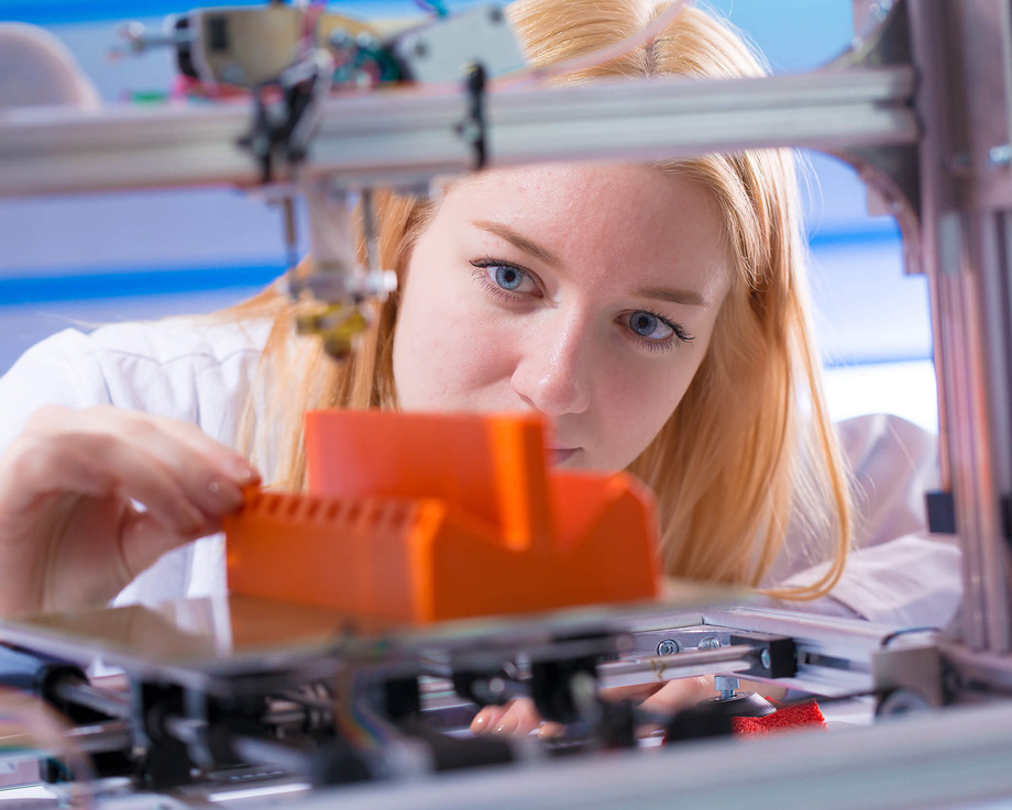 Eine junge Auszubildende zur technischen Produktdesignerin bedient einen modernen 3D-Drucker im BBWN.