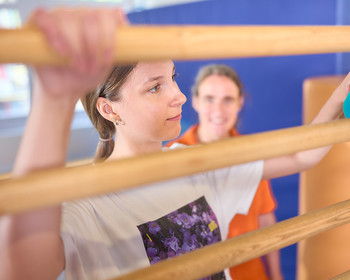 Zwei Frauen auf einem Klettergerüst, führen eine Übung aus.