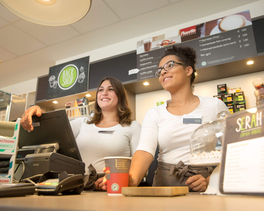 Zwei junge Auszubildende zur Kauffrau im Einzelhandel bedienen im Shop des SRH Berufsbildungswerks Neckargemünd einen Kunden